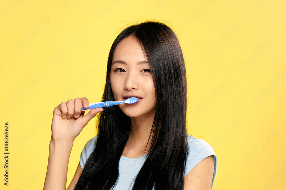 woman, asian appearance, toothbrush, yellow background woman, asian appearance, toothbrush, yellow background