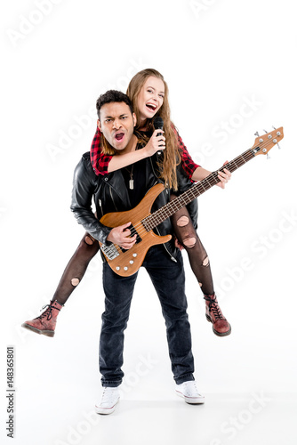 Happy young couple of musicians with microphone and electric guitar performing music together isolated on white
