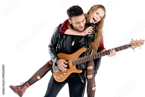 Happy young couple of musicians with microphone and electric guitar performing music together isolated on white
