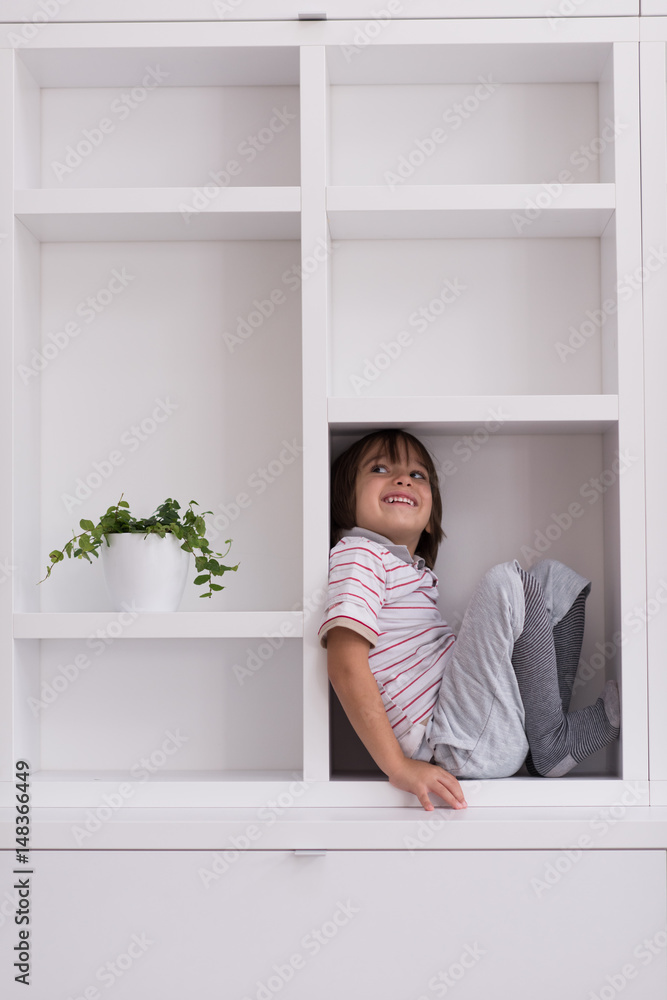 young boy posing on a shelf