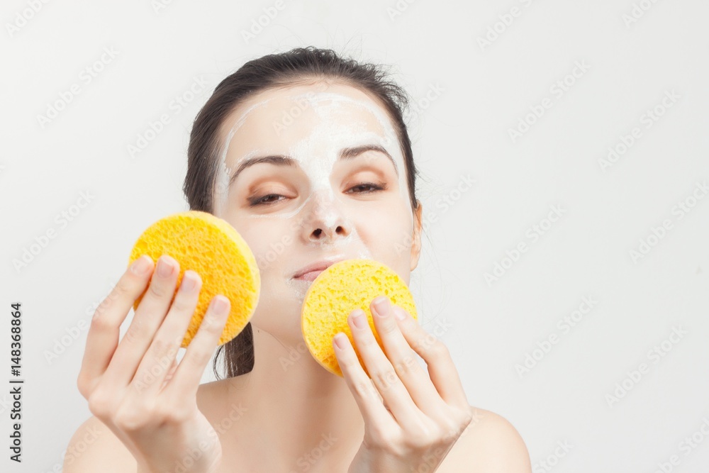 beautiful woman in a light mask and with yellow sponges