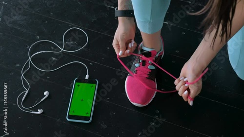 Flat lay of mobile phone with earphone and sport equipment on wood background. Woman in black sneaker with sport equipment, top view 20s 4k. photo