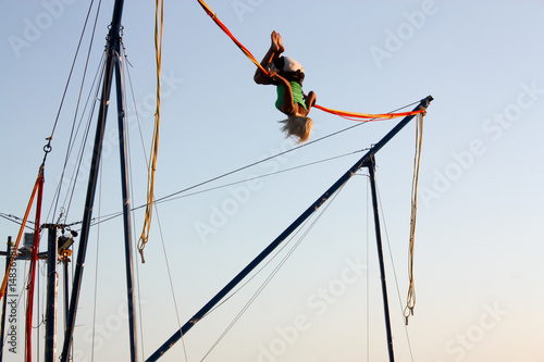 Girl enjoying jumping with ropes on a trampoline