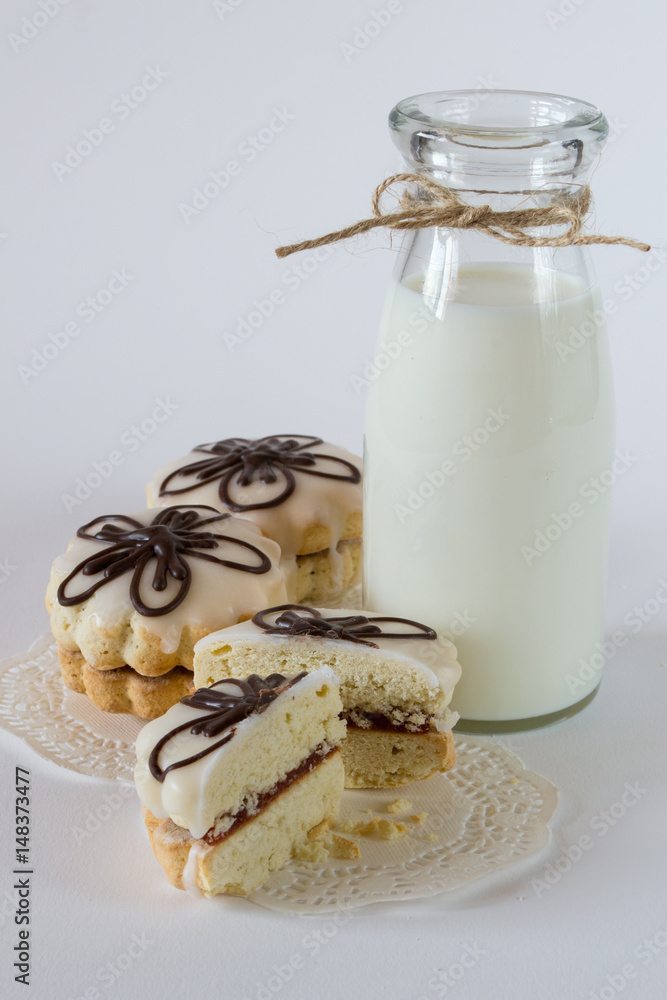 Biscuit decorative cookies with jam and glaze, with  milk on white background