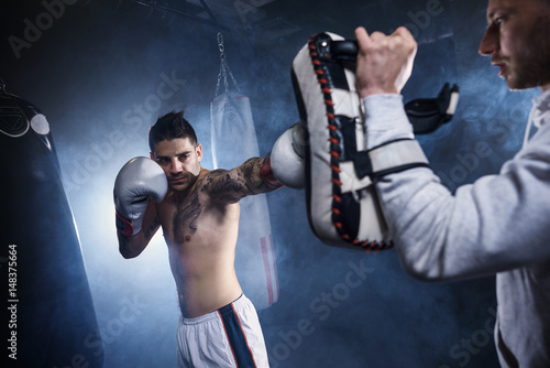 Close up of boxer training with demanding coach © gpointstudio