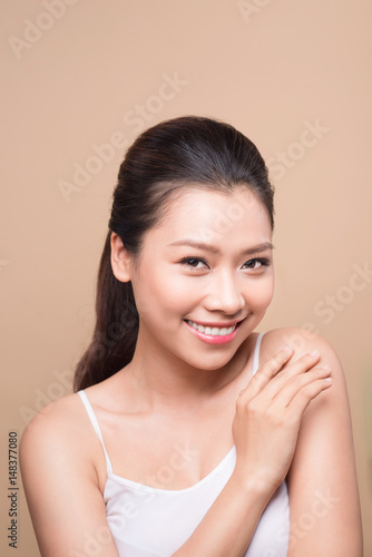 Clean fresh skin concept. Young asian woman touching her shoulder