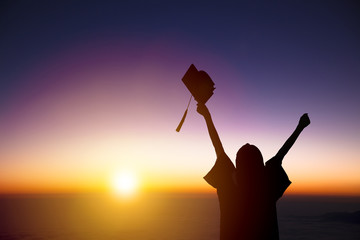 silhouette of Student Celebrating Graduation watching the sunlight.