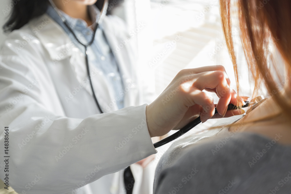 Obraz premium Medical female doctor and patient on white background with the stethoscope, blood pressure measuring.