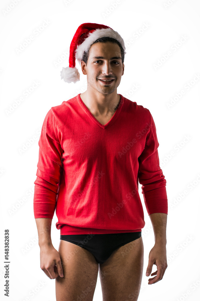 A young man with Santa Claus hat, red wool sweater and underwear, front view. Isolated on white background A young man with Santa Claus hat, red wool sweater and underwear, front view. Isolated on white background