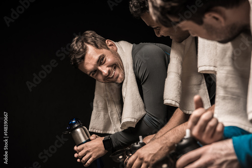 Foto Handsome young athletes resting at gym locker room