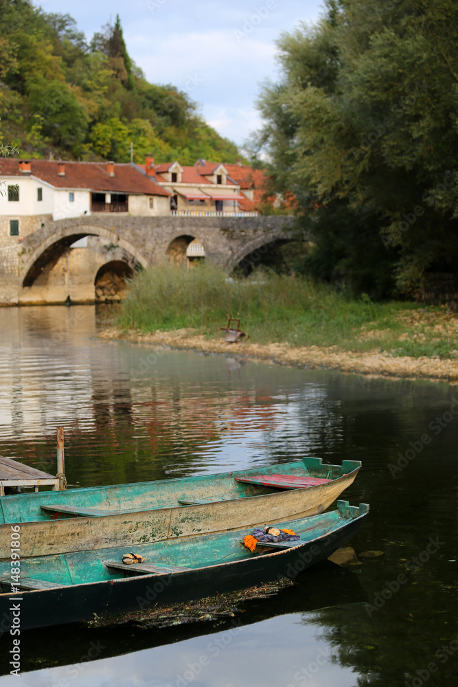 Obraz premium The old town of Rijeka Crnojevica,boats and ancient stone arch bridge