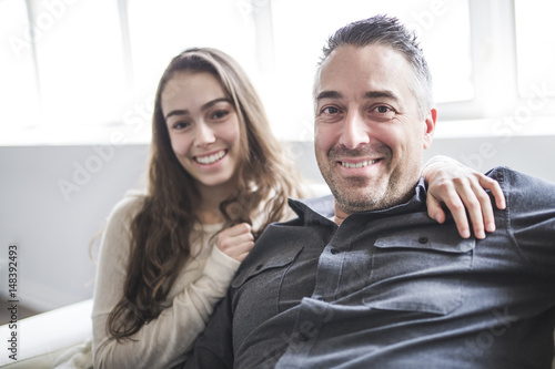 Teenager girl sitting on window with father photo