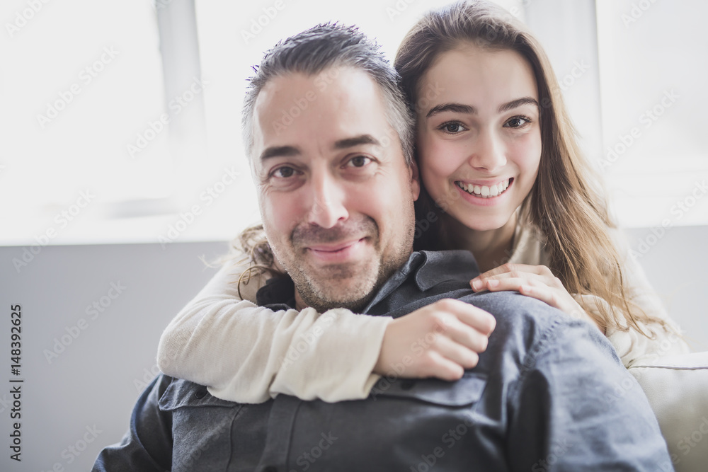 Teenager girl sitting on window with father Teenager girl sitting on window with father