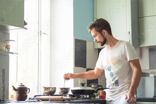 Fotografie A man at home is cooking