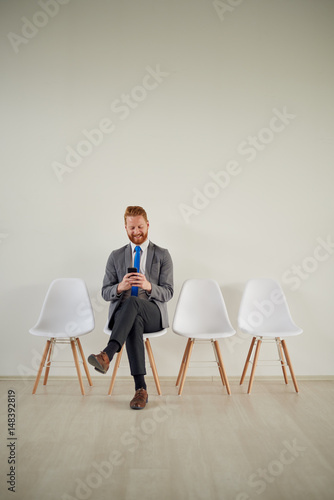 One male in waiting room using cell phone