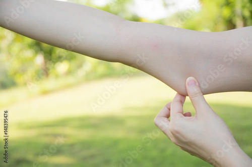 Close up woman with hand holding excessive arm fat on nature background © sek_gt