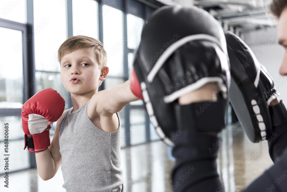 young boy boxer practicing punches with coach young boy boxer practicing punches with coach
