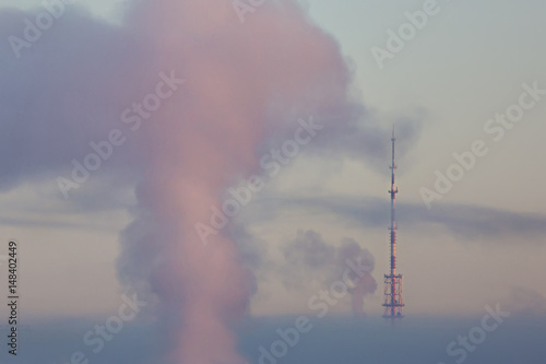 Television tower with cloud of pink steam on a frosty winter morning