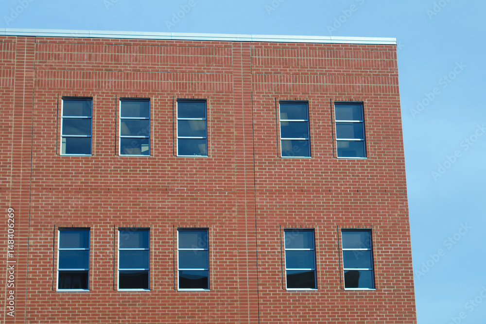 red brick wall and windows on blue sky