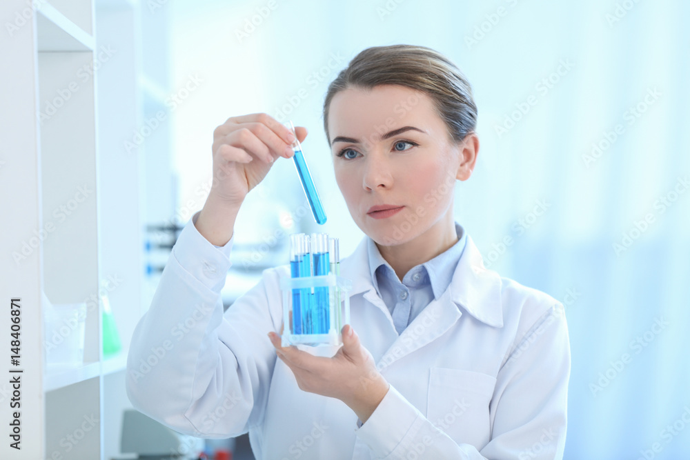 Scientist holding test tube with sample in laboratory Scientist holding test tube with sample in laboratory