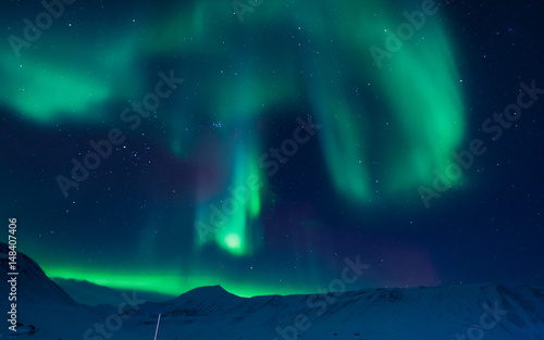 The polar Northern aurora borealis lights in Norway Svalbard in the mountains © bublik_polina