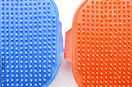 blue and red rubber pet bath brush on white background