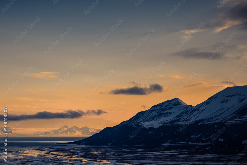 Winter mountain nature Svalbard Longyearbyen Svalbard Norway with blue sky and snowy peaks and blue sky on a sunny day with clouds wallpaper during sunset orange fire