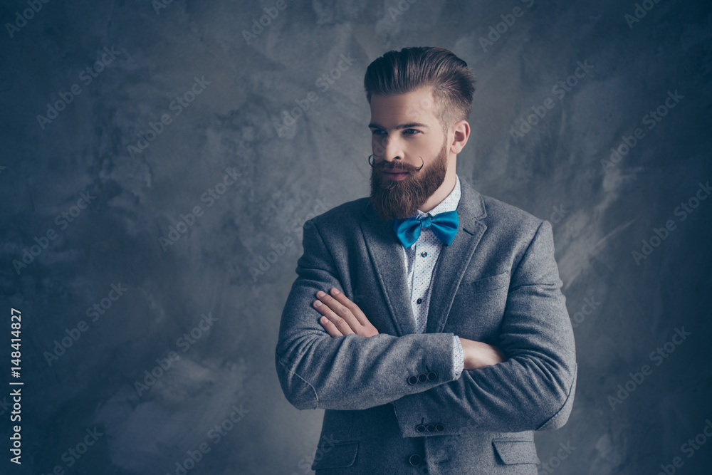 Confident stylish man in suit and bow with beard crossing his hands Confident stylish man in suit and bow with beard crossing his hands
