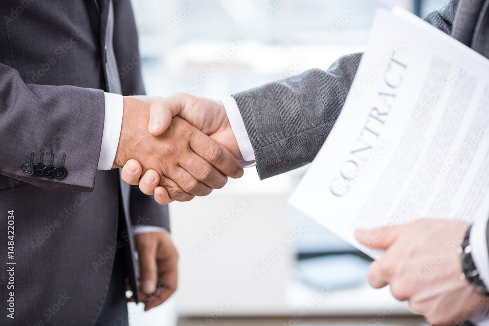 cropped view of businessmen shaking hands in office, business meeting concept cropped view of businessmen shaking hands in office, business meeting concept