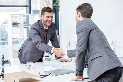 Wallpaper Mural Two smiling businessmen shaking hands at meeting in office, business concept Torontodigital.ca