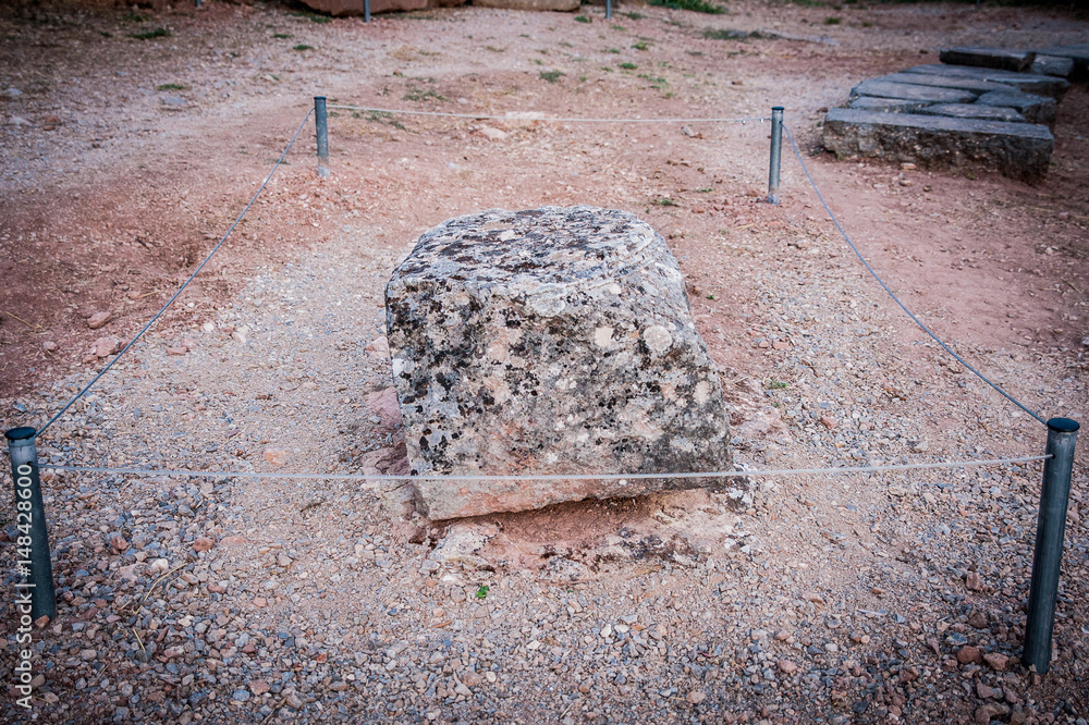 Very important rock with it's own fence. Greece ancient stone in Delphi