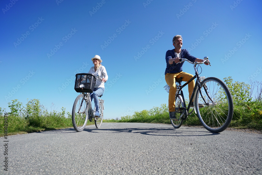 Cheerful couple riding bike on a sunny day