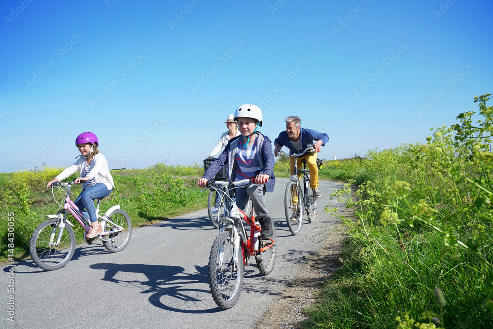 Happy family riding bikes on week-end in countryside Happy family riding bikes on week-end in countryside
