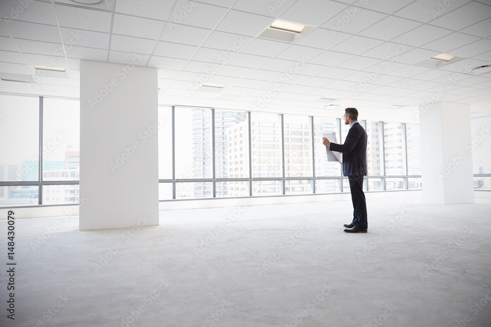 Male Architect In Modern Empty Office Looking At Plans Male Architect In Modern Empty Office Looking At Plans