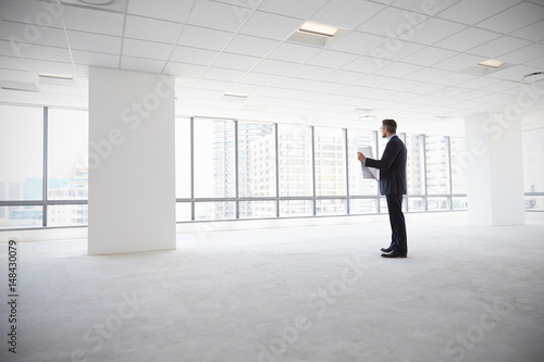 Male Architect In Modern Empty Office Looking At Plans