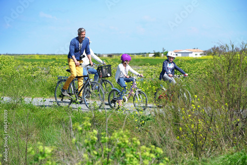 Happy family riding bikes on week-end in countryside