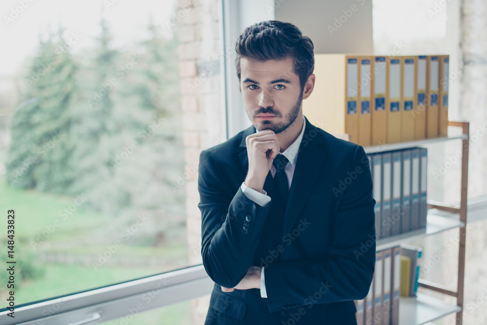 Close up portrait of minded businessman touching his chin and thinking about how to manage a situation connected with new project Close up portrait of minded businessman touching his chin and thinking about how to manage a situation connected with new project