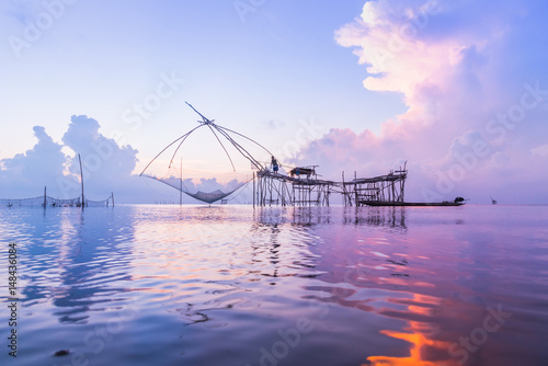 Fisherman catching fish from fish lift net on morning sunrise in Pak Para Canal  Phatthalung  Thailand