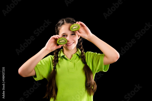 funny girl with sliced kiwi on eyes