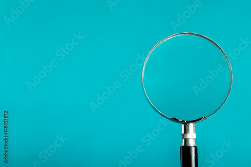 Magnifying glass on blue color background.