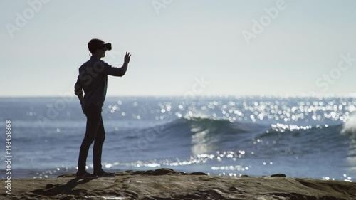 Young man with a virtual reality glasses on a coast