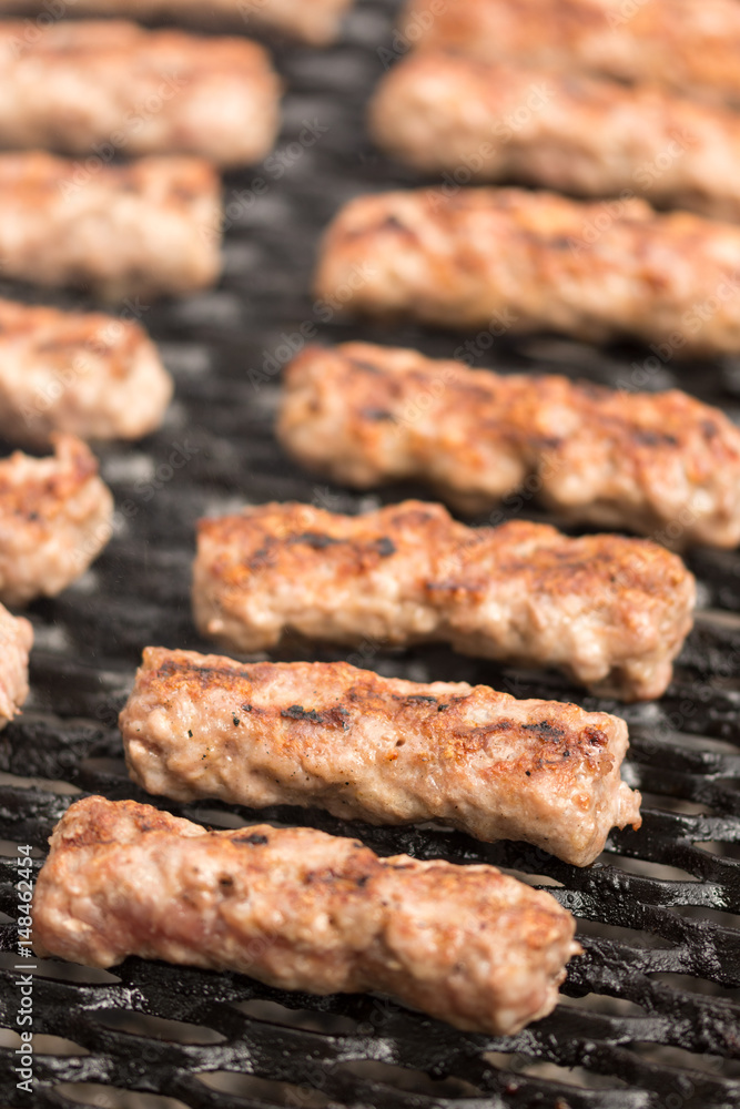 Grilling minced meat kebabs on the barbecue with selective focus