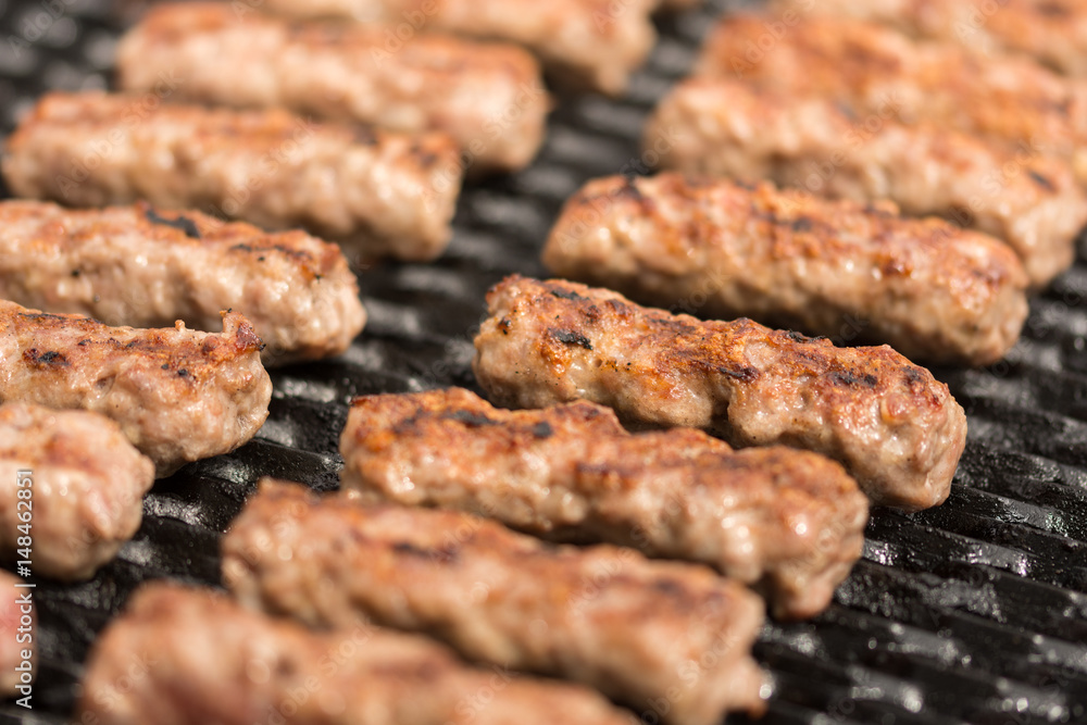 Grilling minced meat kebabs on the barbecue with selective focus