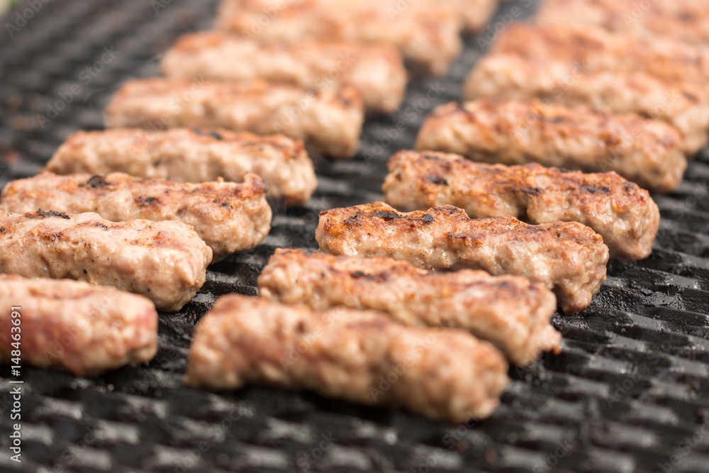 Grilling kebabs on the barbecue grill. Selective focus on the minced meat kebabs