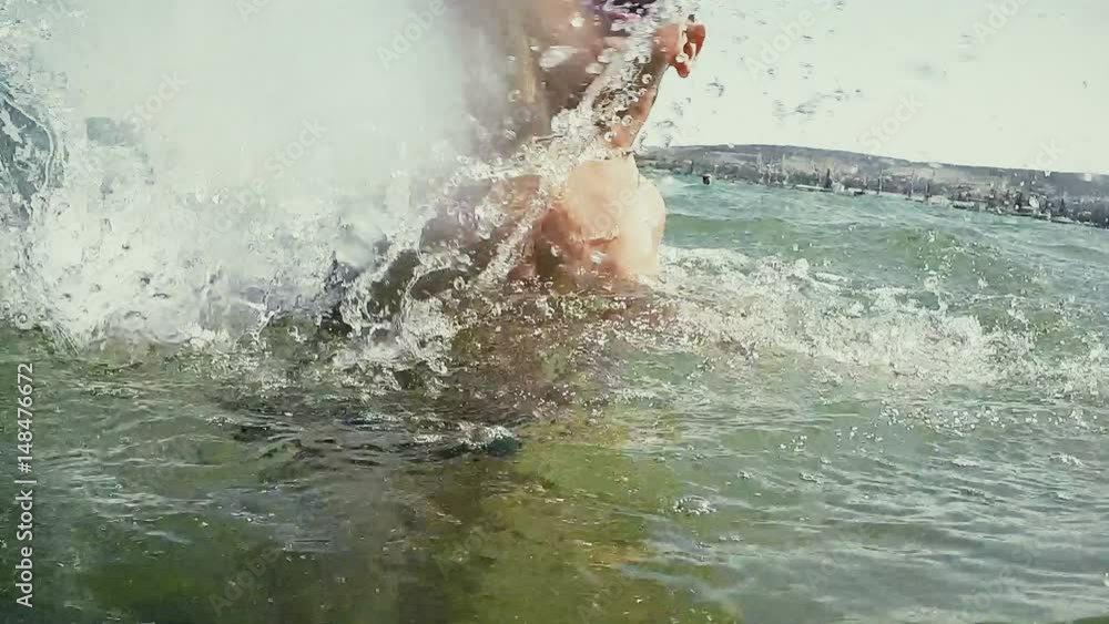 boy makes a spray of water into the sea boy makes a spray of water into the sea