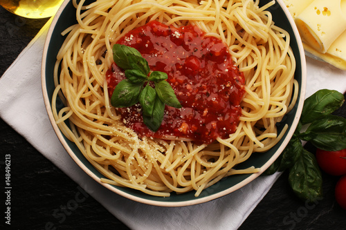 Plate of delicious spaghetti Bolognaise or Bolognese with savory minced beef and tomato sauce garnished with parmesan cheese and basil
