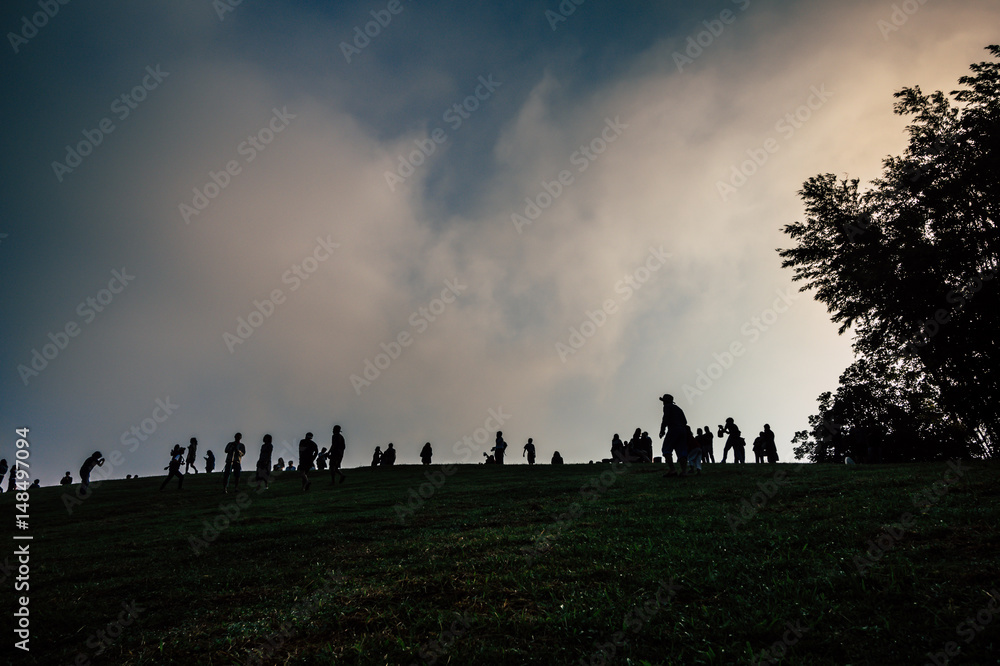 silhouette image, crowd of people on top of hill, abstract emotion blur of people group while sunrise. Concept idea of travel business or competition. Motivation idea to promote team.