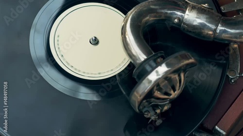 Tonearm needle of the old vintage gramophone slides along the track of the retro plate top-view