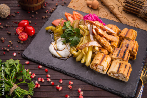 Traditional Arab shawarma with stuffing of the chicken fillet fried on coals, pickles and garlick sauce photo