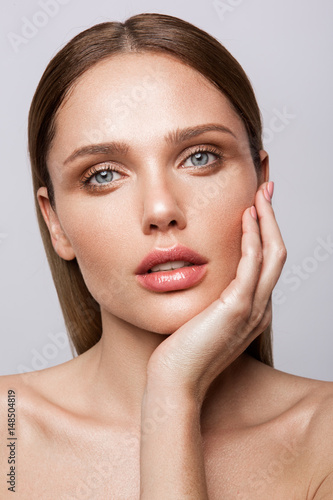 Beauty portrait of model with natural make-up. Fashion shiny highlighter on skin, sexy gloss lips make-up